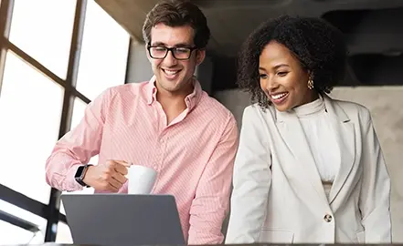 Image of two people looking at laptop